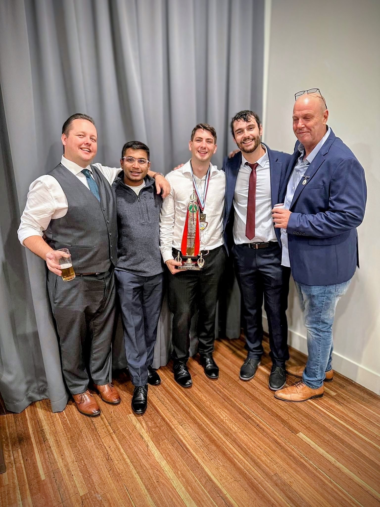 Five club members posing together in formal clothes at presentation night.